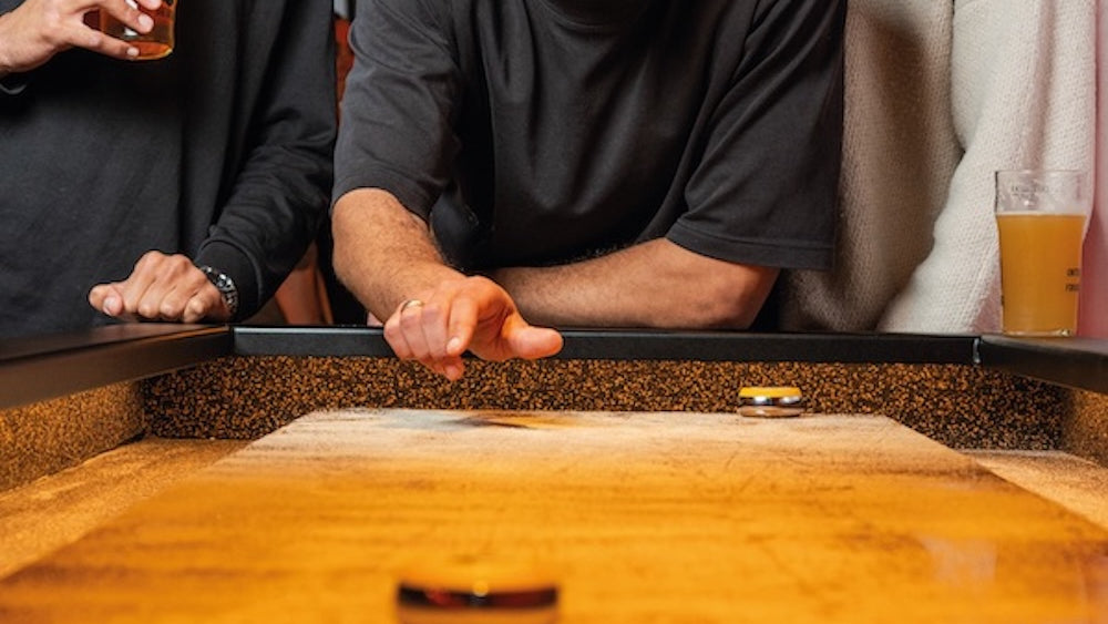 Partie de shuffleboard avec cocktail chez Pucks