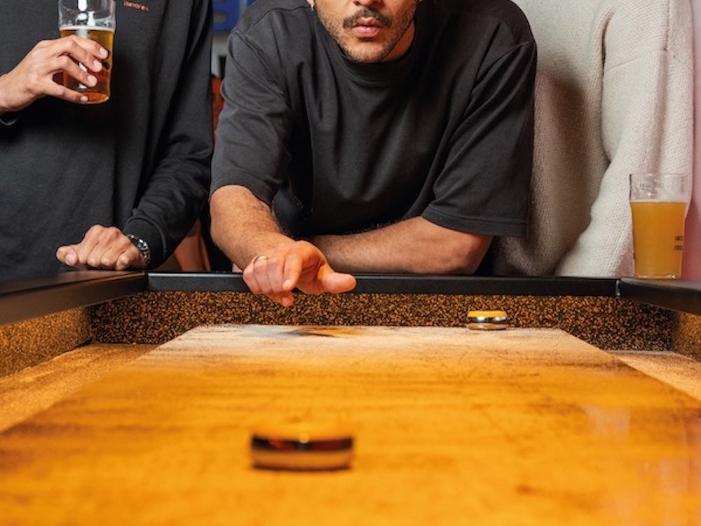 Partie de shuffleboard avec cocktail chez Pucks