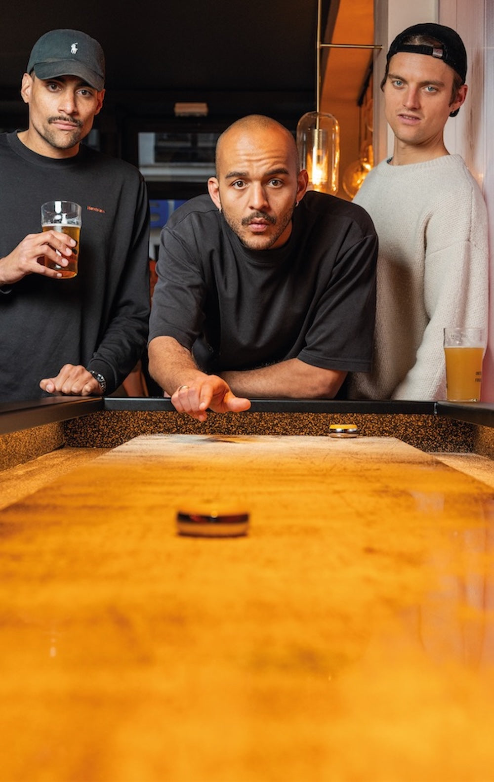Partie de shuffleboard avec un cocktail chez Pucks